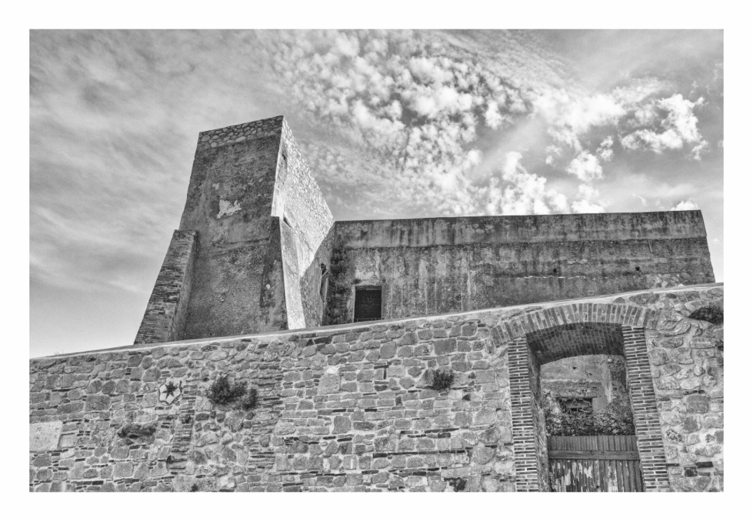Rural architecture print, 120 × 80 cm with white border — a stone building behind a thick fortified wall in a hilltop town, Abruzzo, black and white architectural photography by Tom Parsons