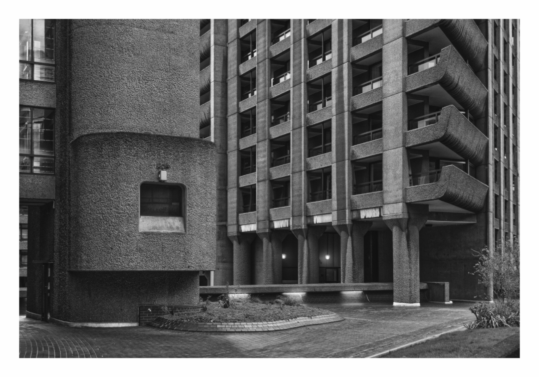Barbican Centre print, 133 × 90 cm with white border — Brutalist concrete tower and cylindrical stair turret at dusk, Barbican Estate, London, black and white architecture photography by Tom Parsons
