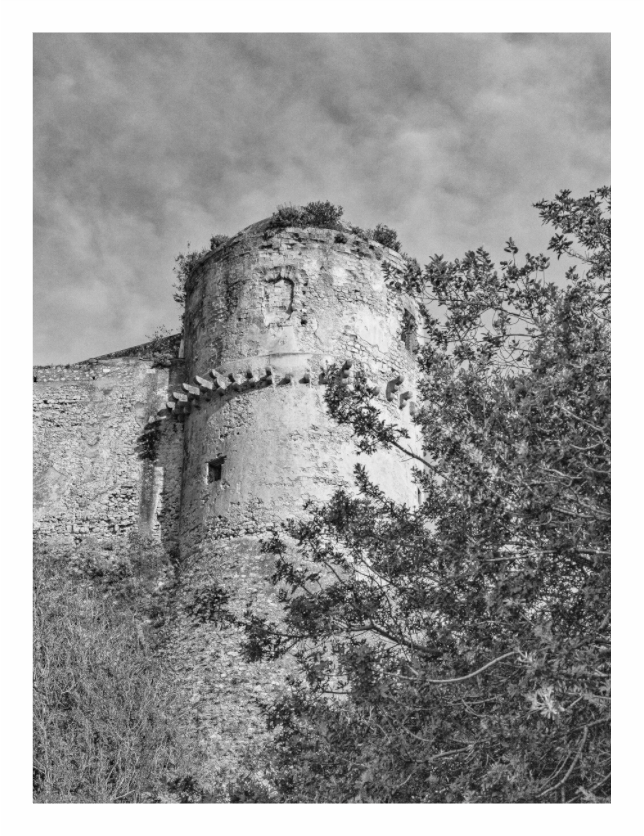 Fortress print, 90 × 120 cm with white border — a round fortified stone tower overgrown with trees, Abruzzo, black and white architectural photography by Tom Parsons