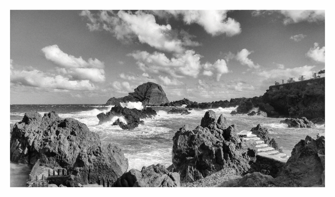 Atlantic Ocean print, 160 × 90 cm with white border — jagged volcanic rocks and breaking waves on the Atlantic coast, Madeira, black and white seascape photography by Tom Parsons
