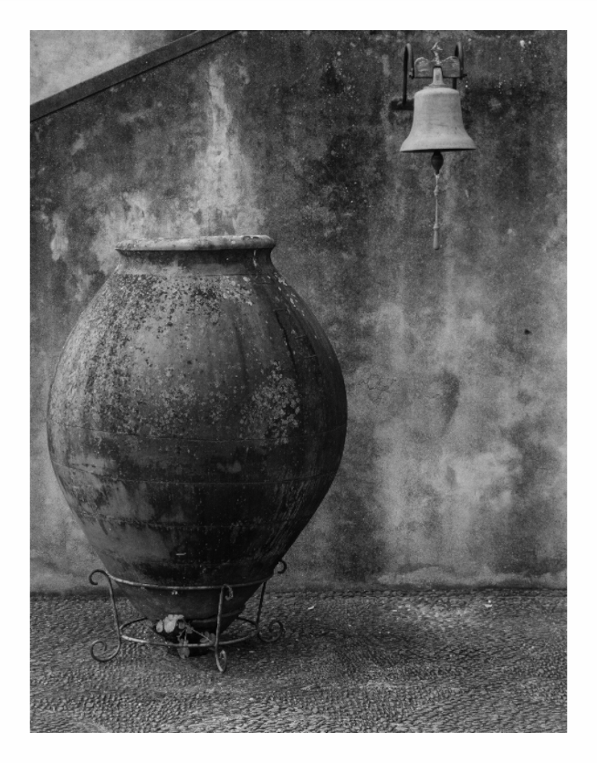 Urn print, 90 x 117.7 cm with white border — ornamental urn and hanging bell against a weathered wall, Monte Palace Tropical Garden, Madeira, black and white still life photography by Tom Parsons