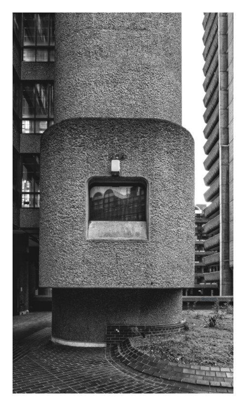 The Barbican print, 90 × 154 cm with white border — a cylindrical concrete stair tower rising between residential blocks, London, black and white architectural photography by Tom Parsons