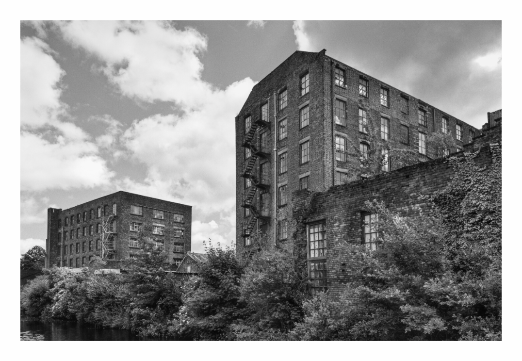 Canal Warehouse print, 120 × 80 cm with white border — Victorian brick warehouse with fire escapes beside the canal, Manchester, black and white architecture photography by Tom Parsons