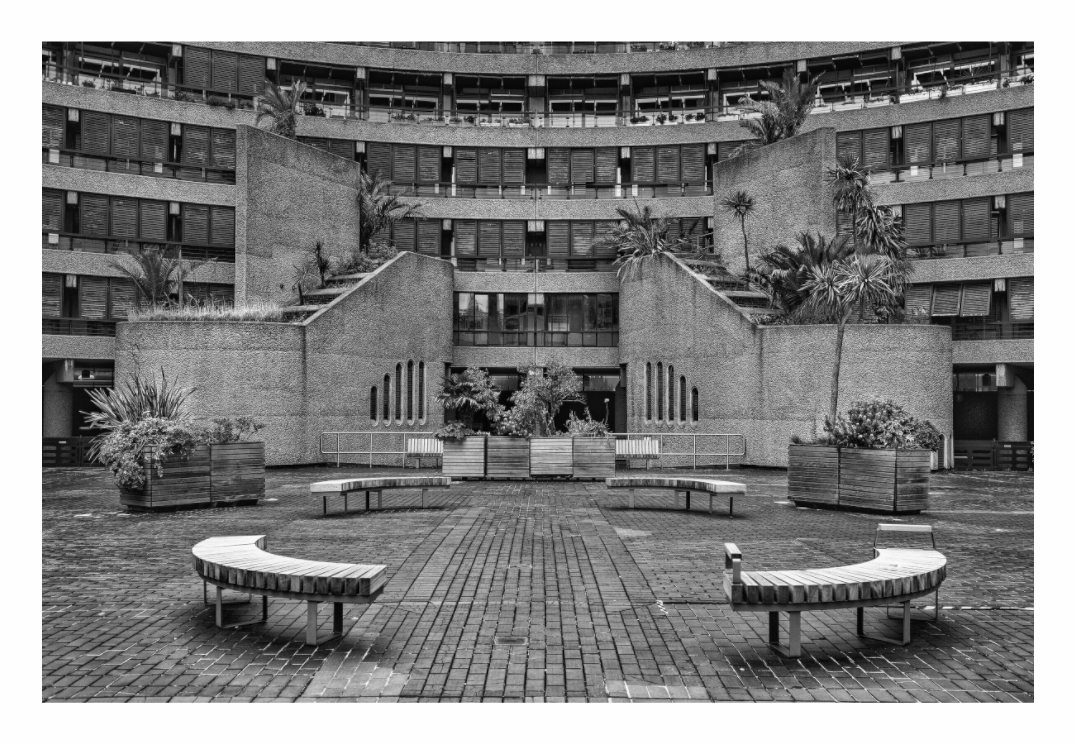 Barbican Centre print, 120 × 80 cm with white border — the circular brutalist courtyard with curved benches and stepped terraces, London, black and white architectural photography by Tom Parsons