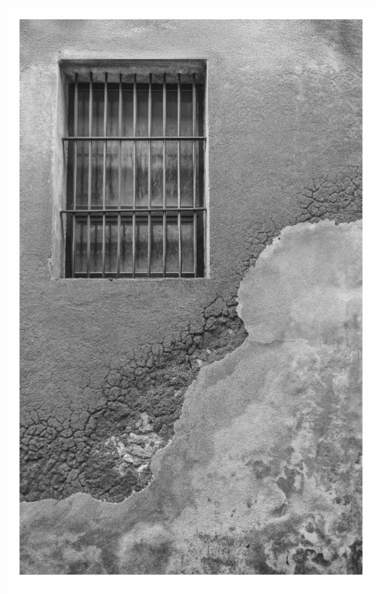 Window print, 90 × 145.6 cm with white border — barred window set into a heavily textured, crumbling wall, Lazio, Italy, black and white architecture photography by Tom Parsons